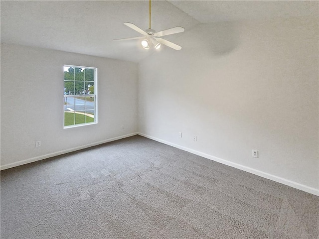 empty room with lofted ceiling, ceiling fan, and carpet flooring