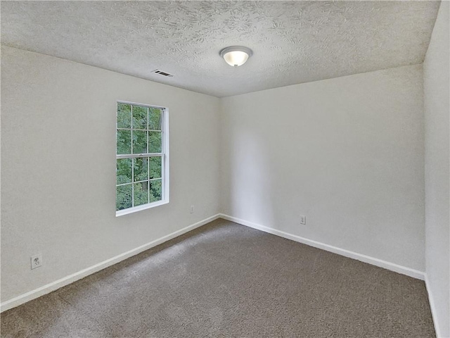 carpeted spare room featuring a textured ceiling