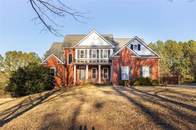 view of front of home featuring a front yard and brick siding