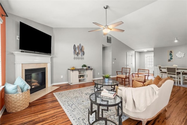 2125 Mina Lane Dr, Buford, GA 30518 - living area featuring wood finished floors, a ceiling fan, vaulted ceiling, a tile fireplace, and baseboards