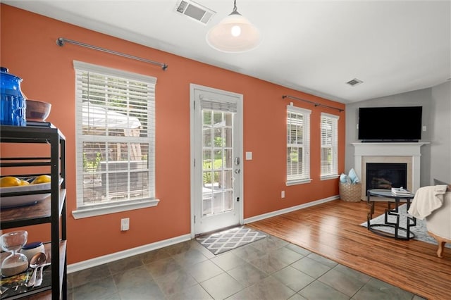 2125 Mina Lane Dr, Buford, GA 30518 - doorway to outside featuring a glass covered fireplace, tile patterned flooring, lofted ceiling, and baseboards