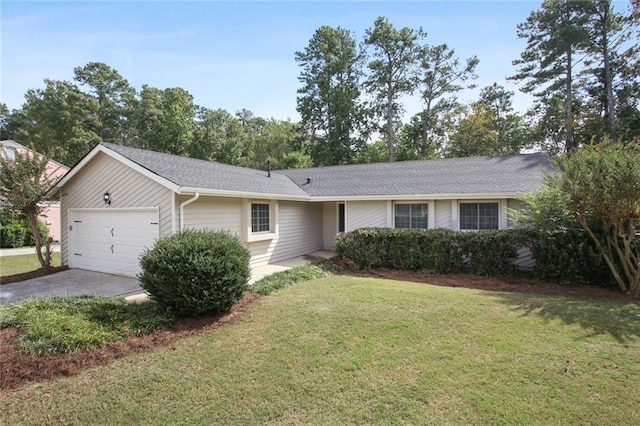 single story home with concrete driveway, a front lawn, and an attached garage