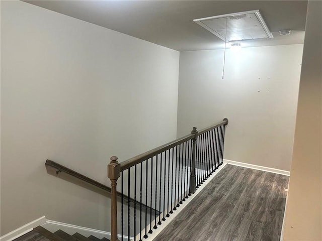 stairs featuring wood finished floors, attic access, and baseboards