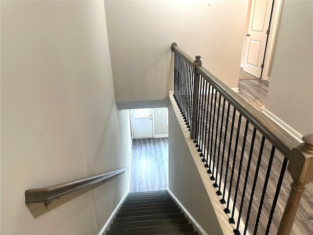 stairway with wood finished floors and baseboards