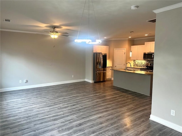 unfurnished living room with baseboards, visible vents, a ceiling fan, ornamental molding, and a sink