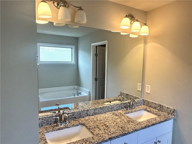 bathroom featuring double vanity, a garden tub, and a sink