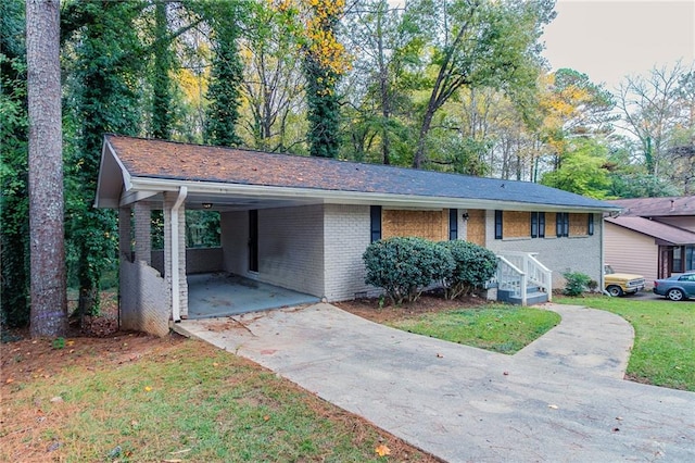 ranch-style home featuring a front lawn and a carport