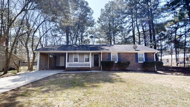 3359 Mansfield Ln, Snellville, GA 30039 - ranch-style home featuring brick siding, an attached carport, a front lawn, a porch, and concrete driveway