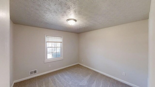 3359 Mansfield Ln, Snellville, GA 30039 - spare room with baseboards, visible vents, carpet floors, and a textured ceiling