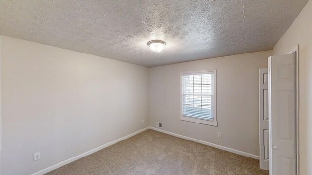 3359 Mansfield Ln, Snellville, GA 30039 - unfurnished room with visible vents, light colored carpet, baseboards, and a textured ceiling