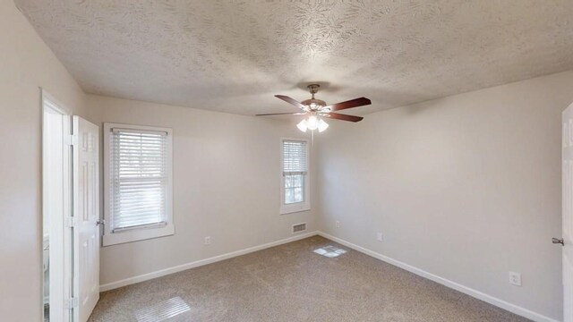 3359 Mansfield Ln, Snellville, GA 30039 - carpeted empty room with a textured ceiling, a ceiling fan, visible vents, and baseboards
