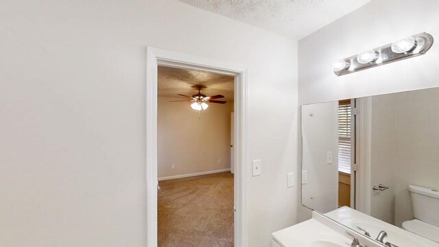 3359 Mansfield Ln, Snellville, GA 30039 - bathroom with toilet, a textured ceiling, baseboards, ceiling fan, and vanity
