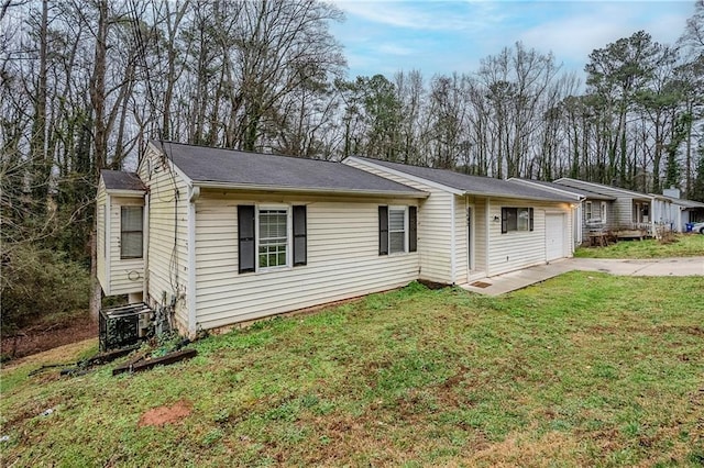 single story home with a front lawn, an attached garage, and driveway