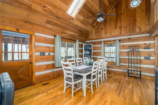 193 Alm Ln, Ellijay, GA 30540 - dining area with wooden walls, a skylight, vaulted ceiling, a ceiling fan, and light wood-style flooring