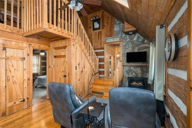 193 Alm Ln, Ellijay, GA 30540 - living area with wooden walls, stairway, wood finished floors, high vaulted ceiling, and a fireplace
