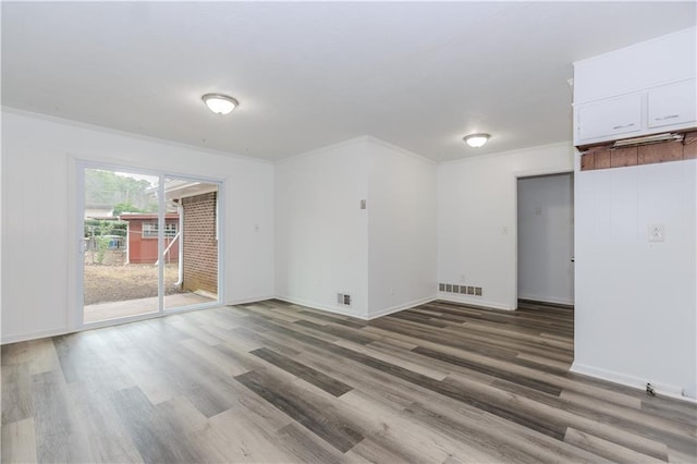 empty room featuring ornamental molding and hardwood / wood-style floors