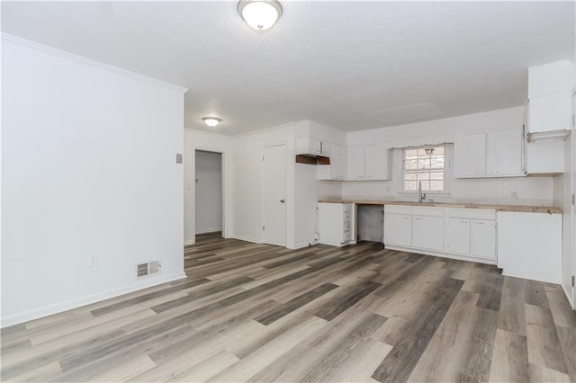 kitchen featuring hardwood / wood-style flooring, sink, and white cabinets