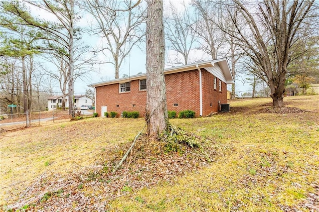 view of home's exterior with central AC and a yard