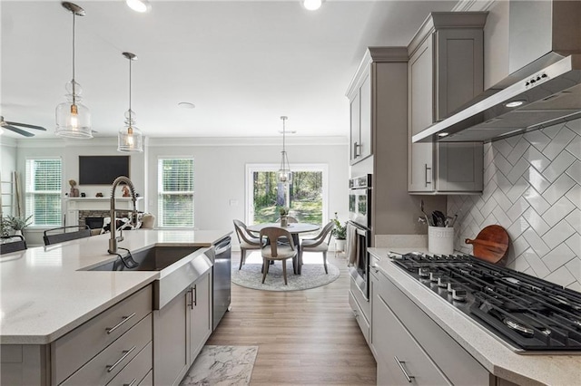 2860 Windsor Knoll Dr, Dacula, GA 30019 - kitchen with wall chimney range hood, appliances with stainless steel finishes, gray cabinetry, crown molding, and backsplash