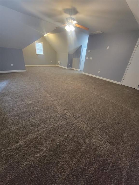 additional living space with vaulted ceiling, ceiling fan, and carpet flooring