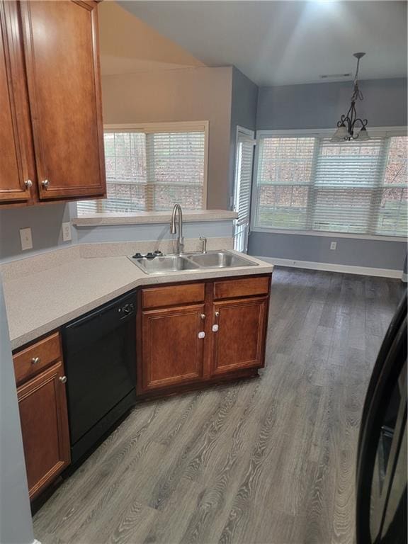 kitchen with dishwasher, sink, hanging light fixtures, and light wood-type flooring