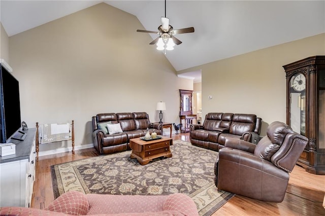 living room with ceiling fan, high vaulted ceiling, and light wood-type flooring