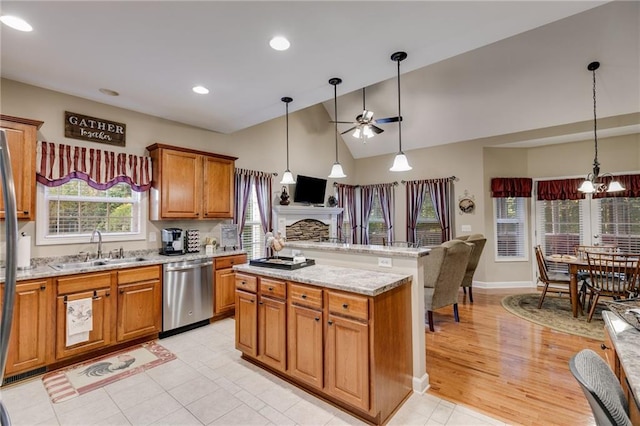 kitchen with hanging light fixtures, dishwasher, sink, and ceiling fan with notable chandelier