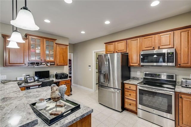 kitchen with hanging light fixtures, light tile patterned floors, sink, and stainless steel appliances