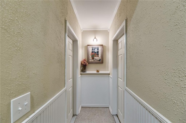 hallway featuring light colored carpet and ornamental molding