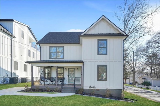 modern inspired farmhouse with roof with shingles, a porch, a front lawn, crawl space, and board and batten siding