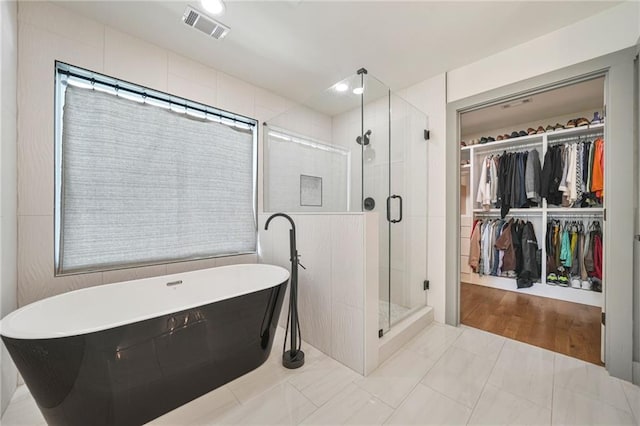 2357 Lynn Iris Dr, Decatur, GA 30032 - full bathroom with tile walls, visible vents, a stall shower, a freestanding bath, and a spacious closet