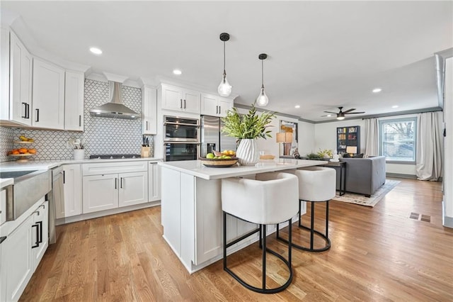 2357 Lynn Iris Dr, Decatur, GA 30032 - kitchen featuring white cabinetry, a ceiling fan, appliances with stainless steel finishes, and wall chimney exhaust hood