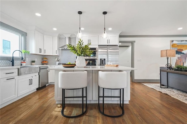 2357 Lynn Iris Dr, Decatur, GA 30032 - kitchen with decorative backsplash, a breakfast bar, stainless steel appliances, a kitchen island, and wall chimney range hood