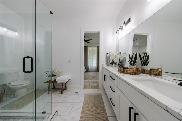 ensuite bathroom with double vanity, a stall shower, marble finish floor, and a sink