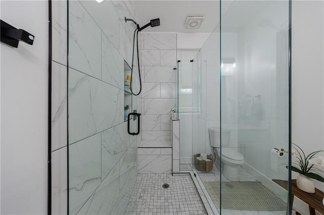 bathroom with a shower stall and toilet