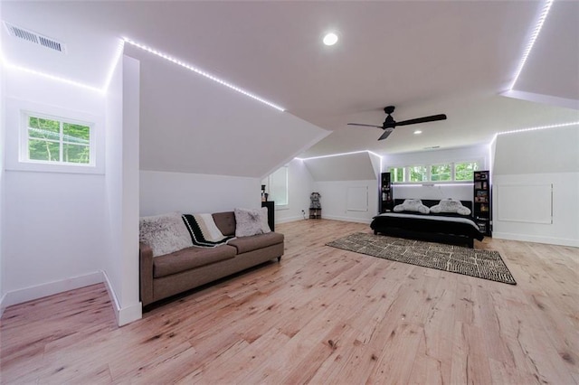 interior space featuring visible vents, lofted ceiling, multiple windows, and wood finished floors