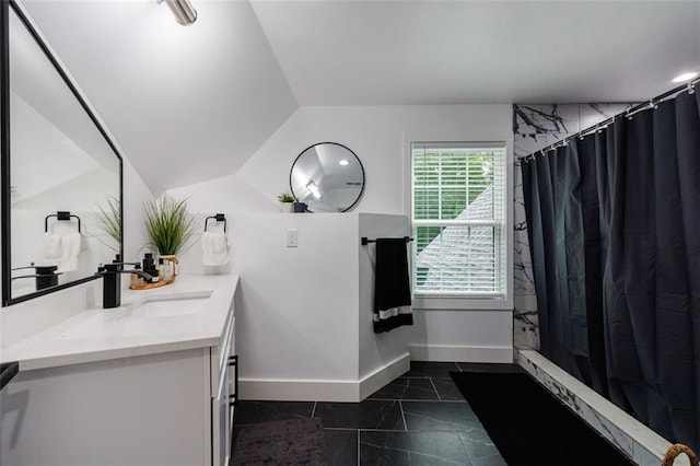 bathroom featuring vanity, vaulted ceiling, curtained shower, and baseboards