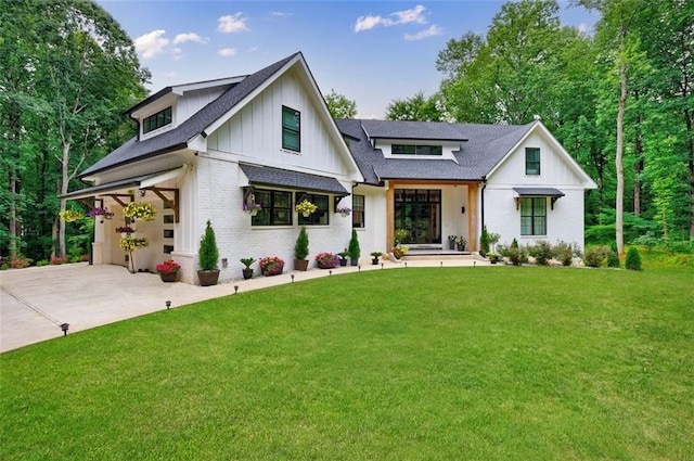 modern inspired farmhouse with driveway, brick siding, a front lawn, a garage, and board and batten siding