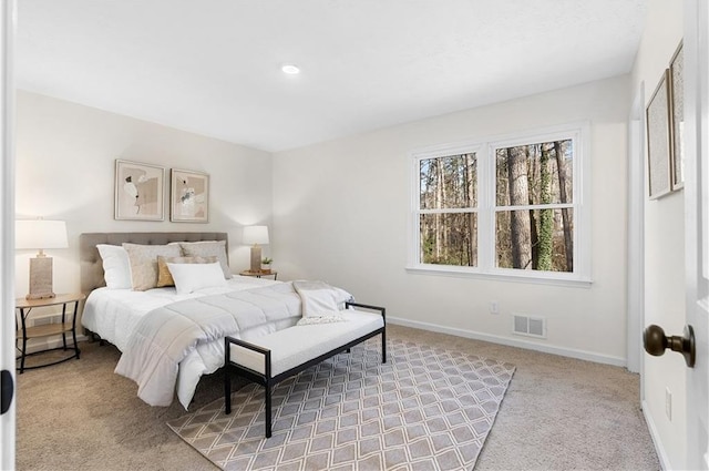 bedroom with visible vents, baseboards, and light carpet