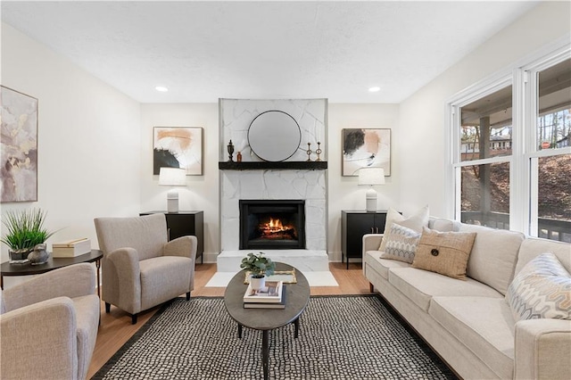 living room featuring a large fireplace, wood finished floors, and recessed lighting