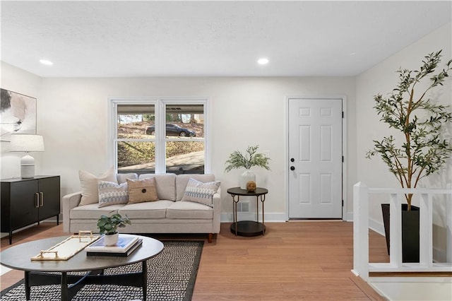 living area with light wood finished floors, baseboards, and recessed lighting