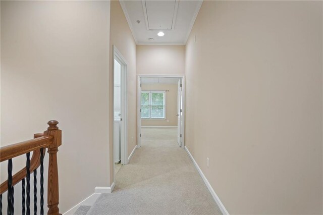 hallway with light colored carpet and crown molding