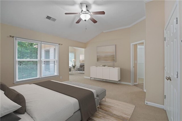 bedroom with ceiling fan, lofted ceiling, light carpet, and ornamental molding