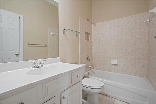 full bathroom with vanity, tiled shower / bath combo, toilet, and tile patterned flooring