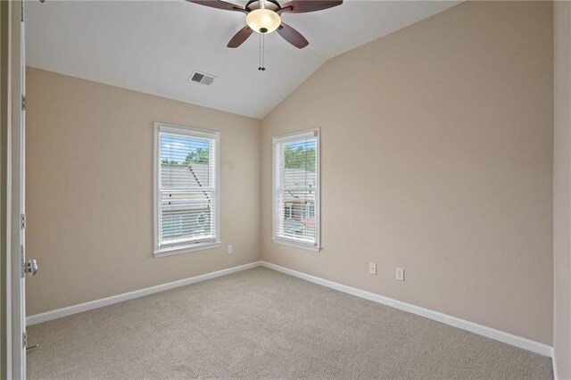 empty room featuring light carpet, lofted ceiling, and ceiling fan