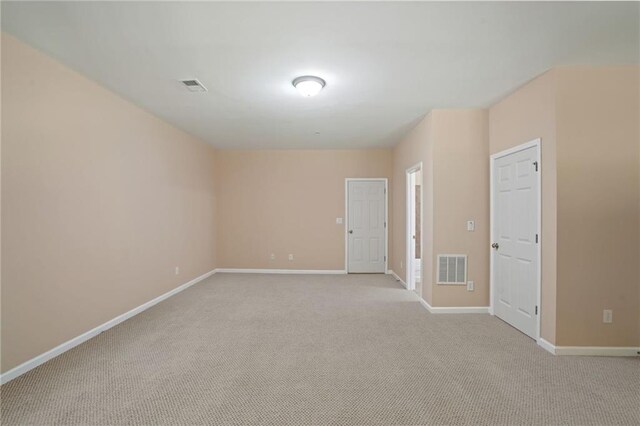 spare room featuring light colored carpet