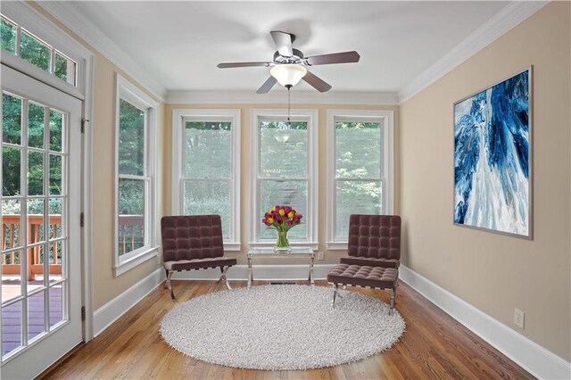 sitting room with hardwood / wood-style flooring, ornamental molding, ceiling fan, and a wealth of natural light