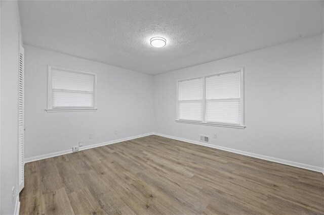 spare room with wood-type flooring and a textured ceiling