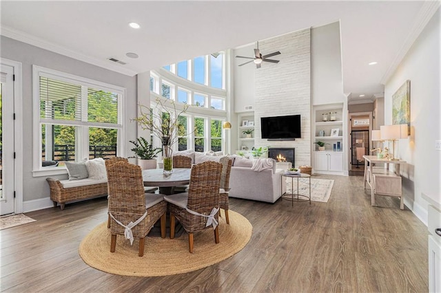 1865 Henley Way, Alpharetta, GA 30009 - dining room with crown molding, a ceiling fan, a fireplace, wood finished floors, and baseboards