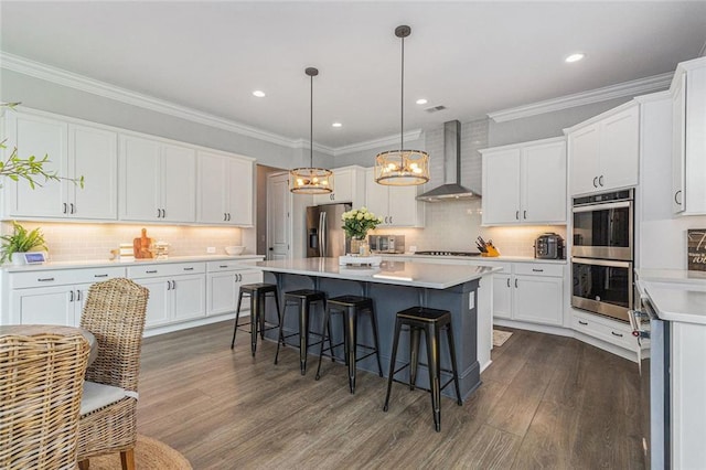 1865 Henley Way, Alpharetta, GA 30009 - kitchen featuring stainless steel appliances, wall chimney exhaust hood, a kitchen breakfast bar, white cabinetry, and crown molding